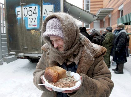 an-elderly-woman-holds-a-plate-of-food-she-receive-1458982448340.jpg