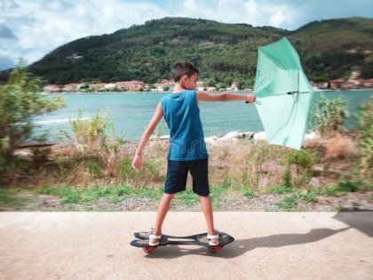 kid-skateboard-wind-umbrella-going-58190845-307753955.jpg