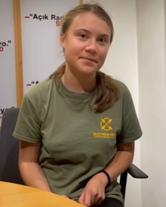 a woman sitting at a table in front of a sign that says ack radio.jpg